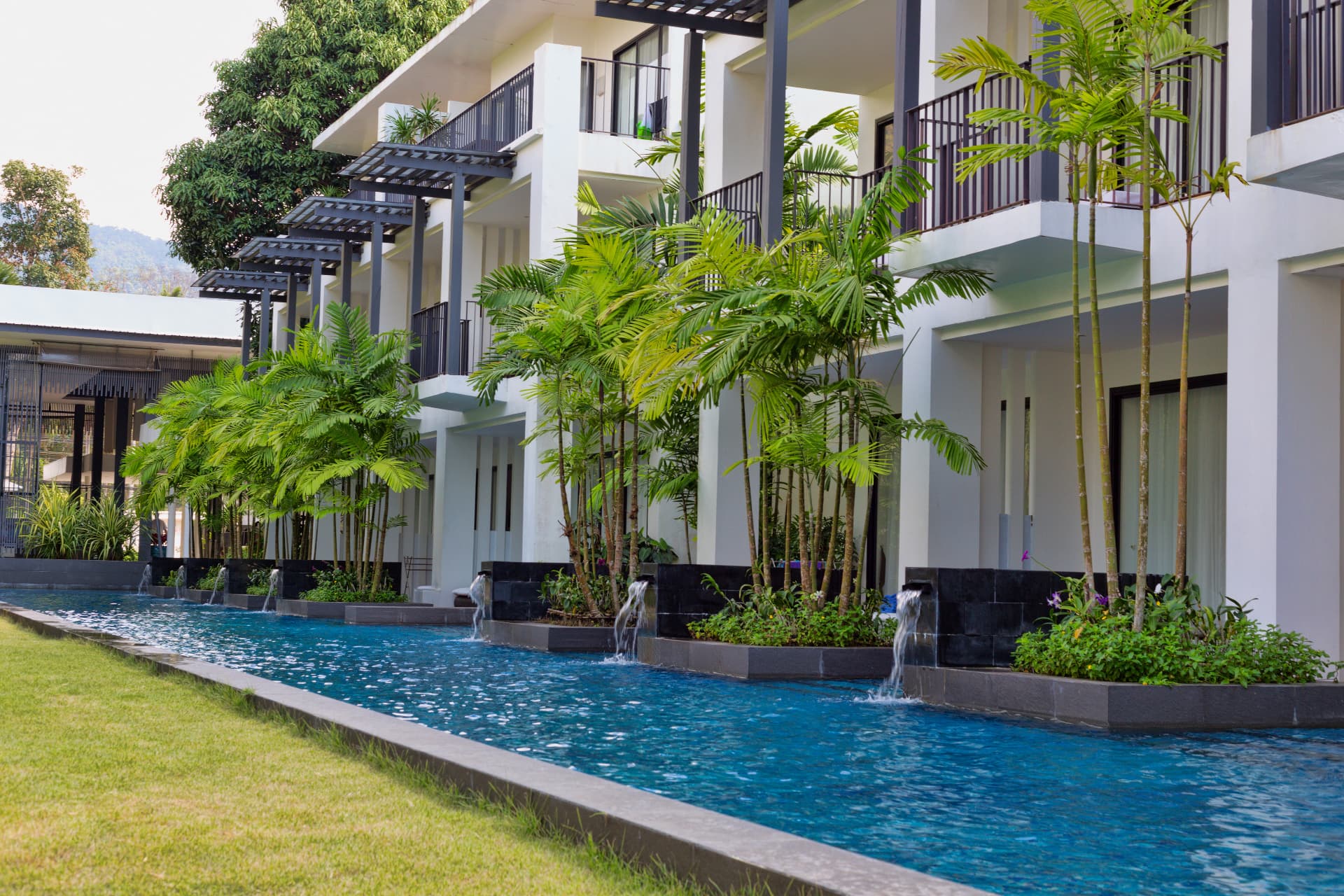 Pool with integrated wall fountains and tropical landscaping